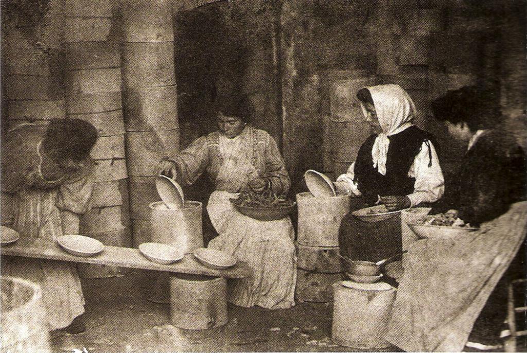 Mujeres preparando la loza en las cobijas, en el regazo un puñado de atifes, para separar los platos